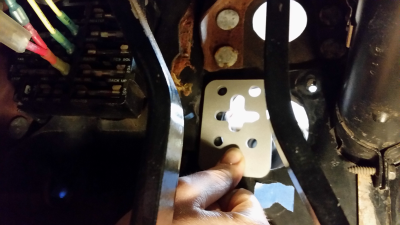 A matching plate on the other side clamps onto the firewall to spread the loading.